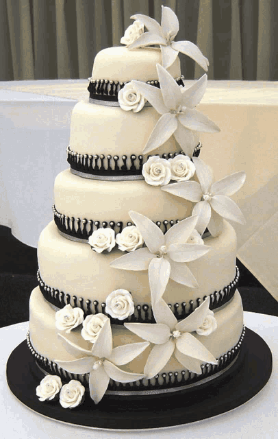 a black and white wedding cake with white flowers on top