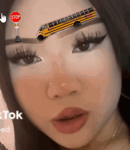 a girl has a school bus on her forehead and a stop sign