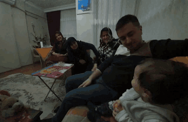 a group of people are sitting on a couch with a baby