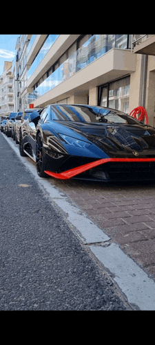 a row of sports cars parked on the side of a street