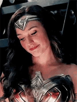 a close up of a woman in a wonder woman costume smiling .