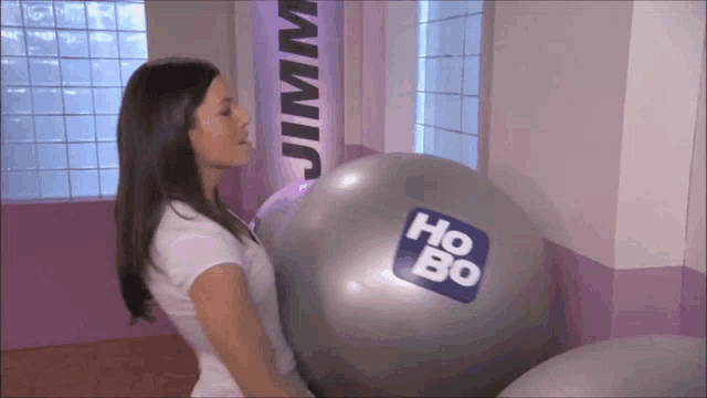 a woman is holding a giant exercise ball that says ho bo