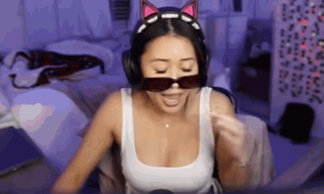 a woman is wearing headphones and sunglasses while playing a video game .