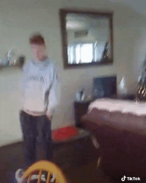 a blurry picture of a person standing in a living room with a mirror .