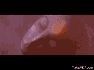 a close up of a person 's face in a bathtub with a purple background .