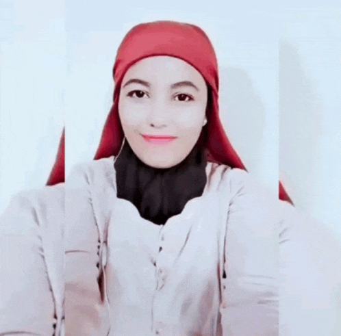 a woman wearing a red head scarf and a white sweater