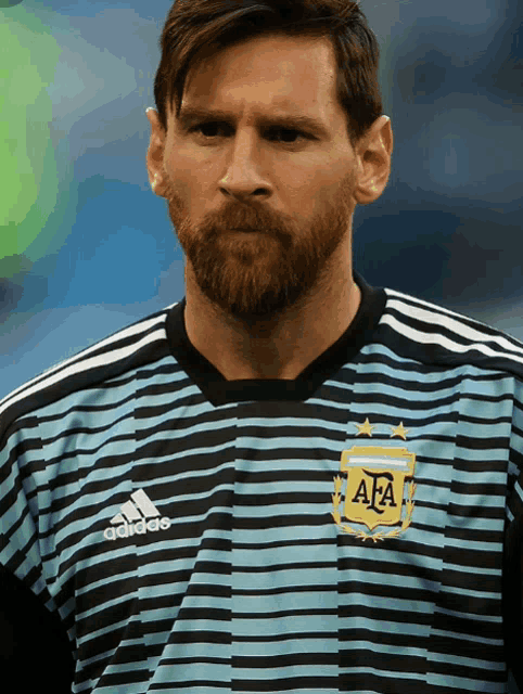 a man with a beard wears a striped adidas shirt