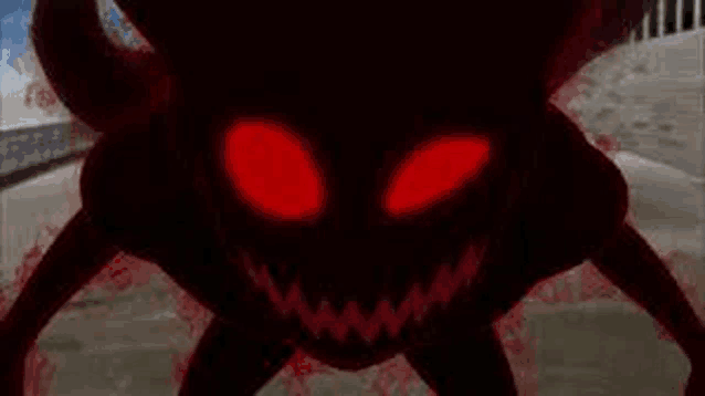 a close up of a monster with red eyes and sharp teeth in the dark .