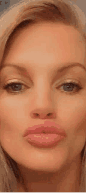 a close up of a woman making a funny face with her lips .