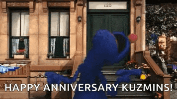 elmo is dancing in front of a building with the words happy anniversary kuzmins on the bottom