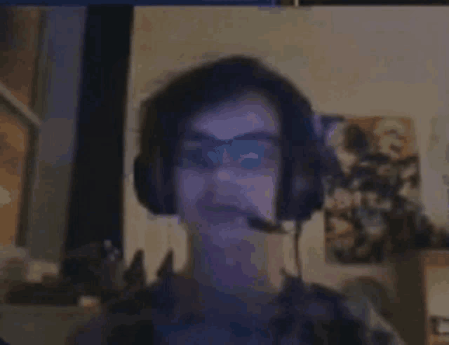 a man wearing headphones and a microphone is looking at the camera .
