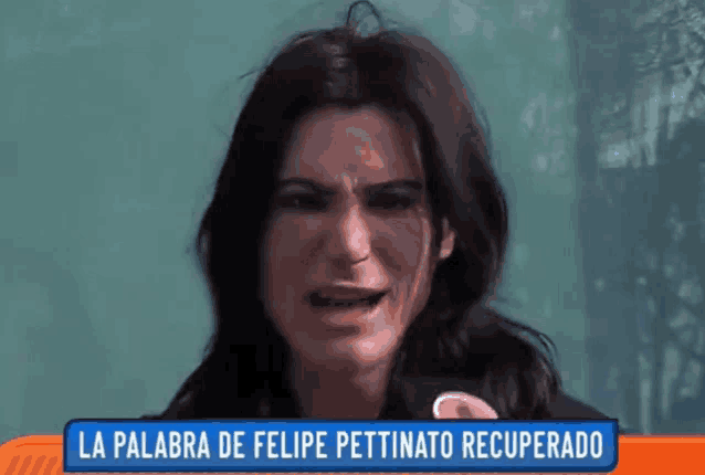 a woman is crying in front of a sign that says la palabra de felipe pettinato recuperado