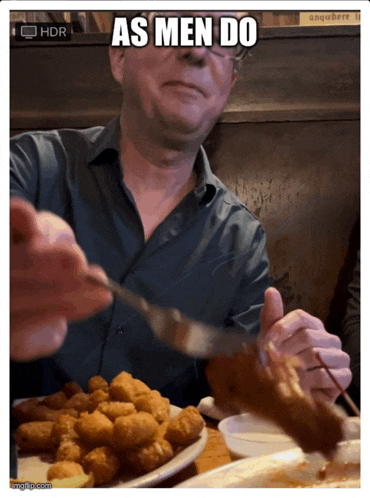 a man sitting at a table with a plate of food and the caption as men do