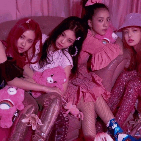 a group of girls are sitting on a couch holding stuffed animals .