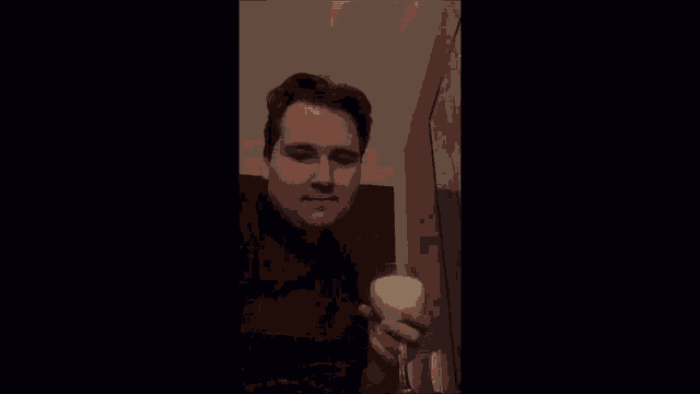 a man in a plaid shirt is holding a glass of wine