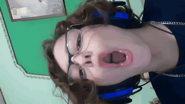 a person wearing glasses and headphones making a face