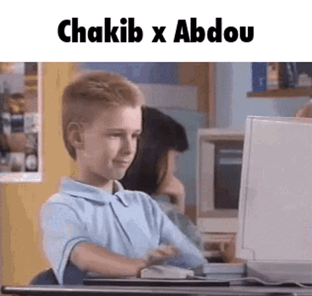 a young boy is sitting at a desk in front of a computer screen with the words chakib x abdou above him .