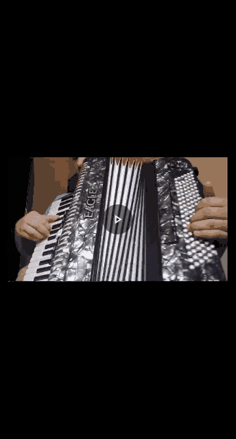 a close up of a person playing an accordion on a black background .