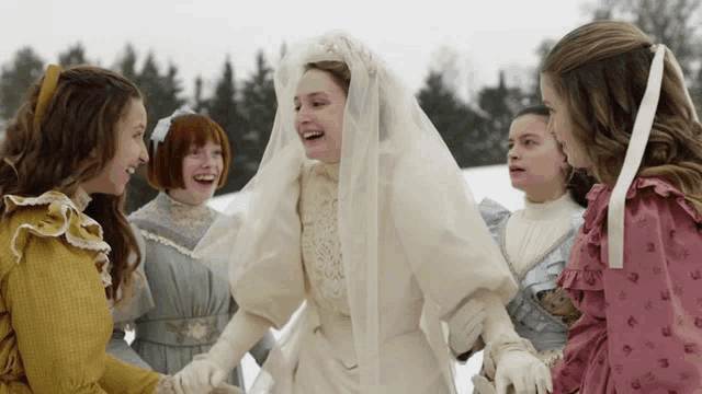 a woman in a wedding dress and veil is surrounded by other girls