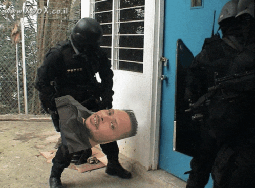 a group of soldiers are standing in front of a blue door with a picture of a man on the ground in front of them