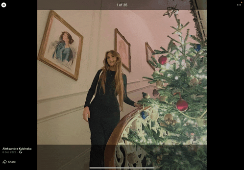 a woman in a black dress is standing next to a christmas tree with the caption aleksandra kubinska