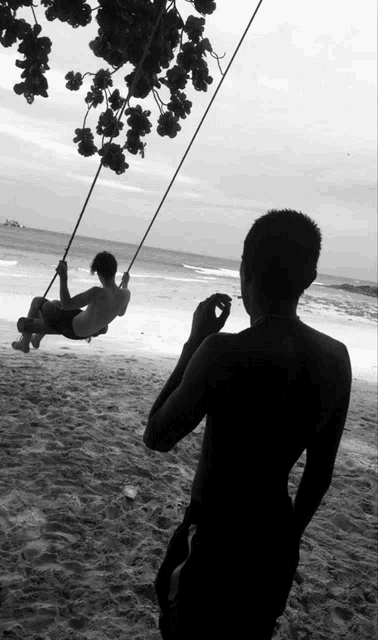 a man is taking a picture of another man on a swing