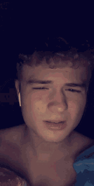 a young man wearing ear buds looks at the camera