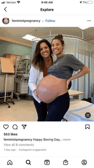 a woman with a very large belly is posing for a picture with a doctor