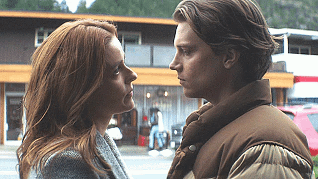 a man and a woman are looking at each other