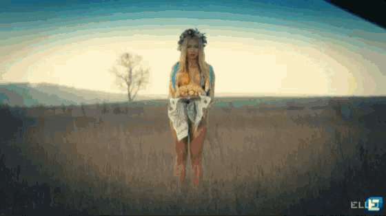 a woman standing in a field with the letters elb on the bottom left