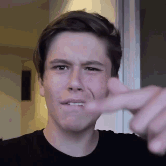 a young man making a funny face with his finger