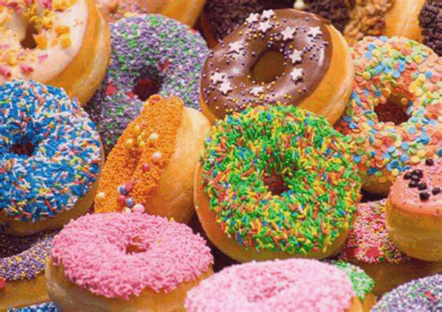 a bunch of donuts with different toppings and sprinkles on them .