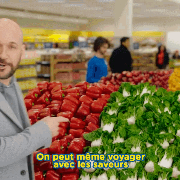 a man standing in front of a display of vegetables with the words on peut meme voyager avec les saveurs