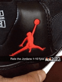 a person is holding a pair of black jordans