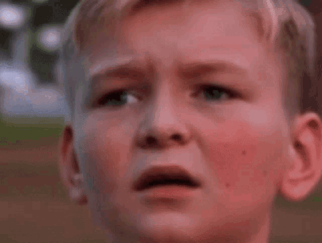 a close up of a boy 's face with a surprised look on his face