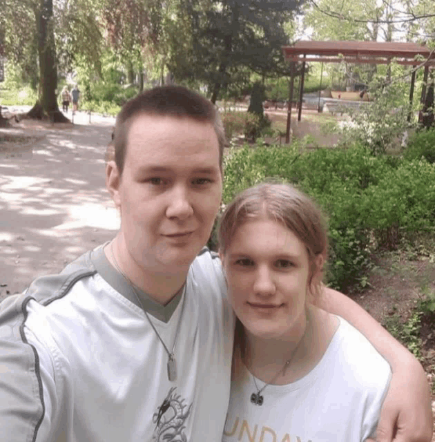 a man and a woman are posing for a picture and the man is wearing a shirt that says sunday