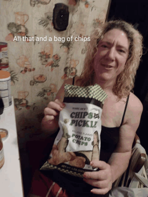 a woman is holding a bag of chips that say chips a pickle