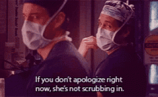 two doctors wearing masks are standing next to each other and one of them says if you don 't apologize right now