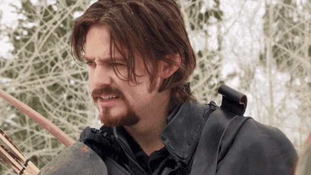 a man with long hair and a beard is holding an arrow