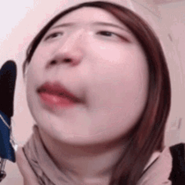 a woman is making a funny face while holding a microphone .