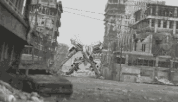 a black and white photo of a robot destroying a building in a city .