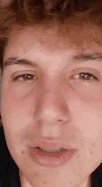 a close up of a person 's face with a black shirt
