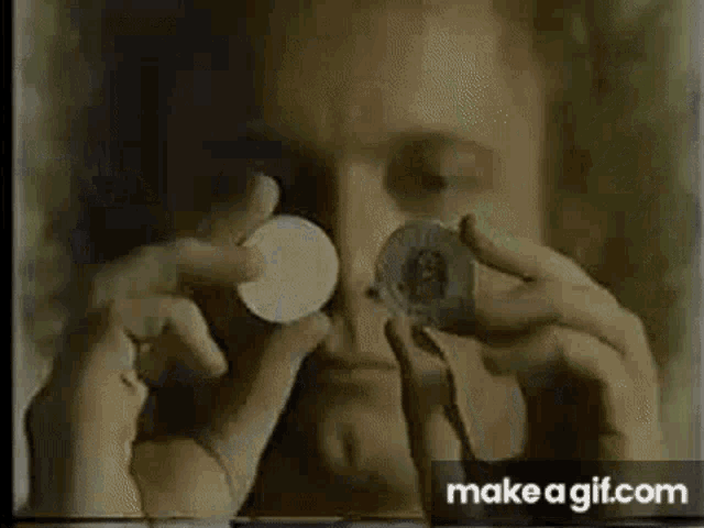a man with curly hair is talking on a cell phone while sitting on a couch .