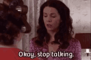 a woman with curlers in her hair is talking to another woman in a bedroom .