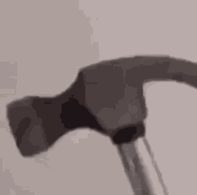 a hammer is being used to break a piece of wood .