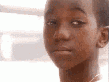a close up of a young boy 's face with a sad look on his face .