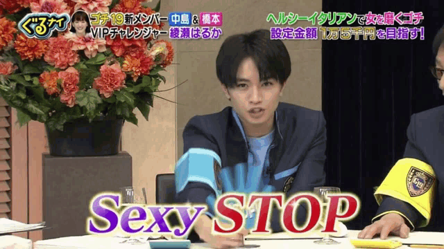 a man sitting at a table with the word sexy stop on the screen