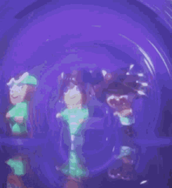a person wearing a glow in the dark crop top is standing in a dark room .