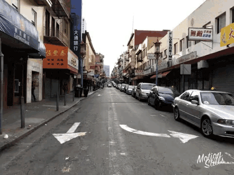 a row of cars are parked on the side of a street in front of a building that has a sign that says flooring