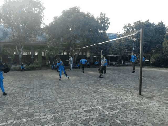 a group of kids are playing volleyball in a court